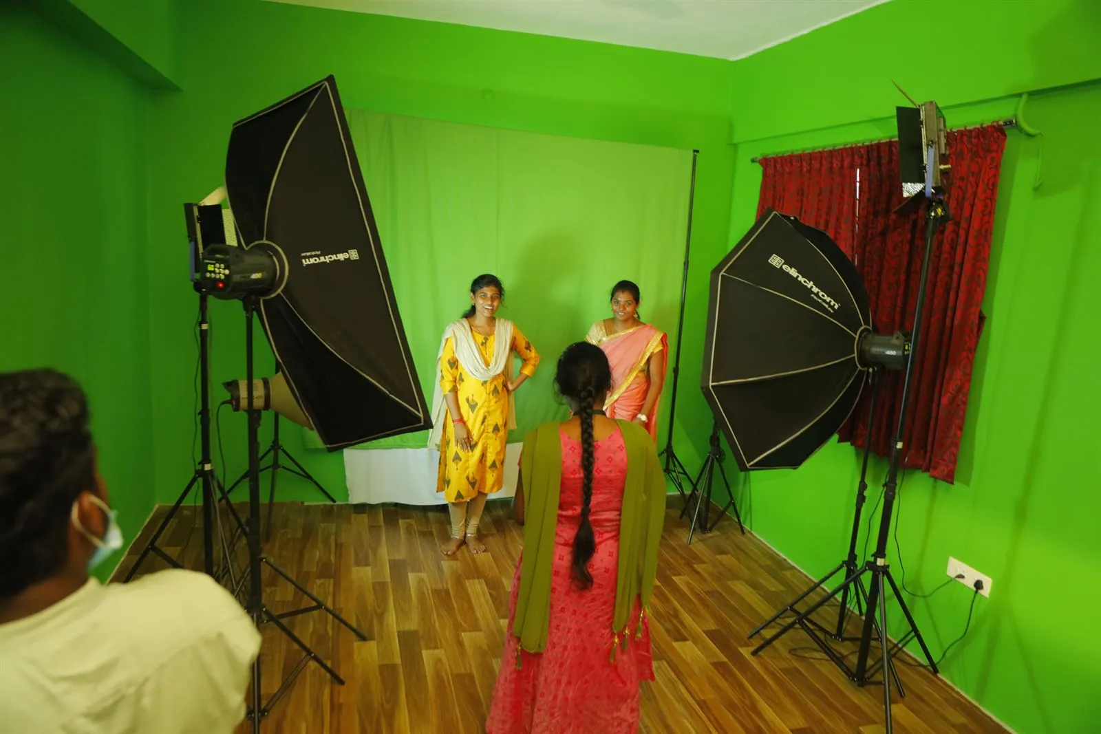 Students at a photo shoot in front of the green screen in the media studio